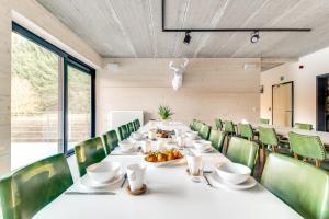 马尔梅迪Daft Boutique Hotel & Glamping的一间带长桌和绿色椅子的用餐室