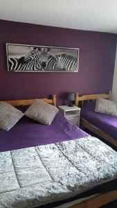 红山Hathway House Accommodation的一间卧室设有两张床和紫色墙壁