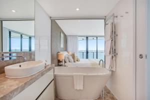 黄金海岸辣椒灵魂冲浪者天堂公寓式酒店的一间带大浴缸和水槽的浴室