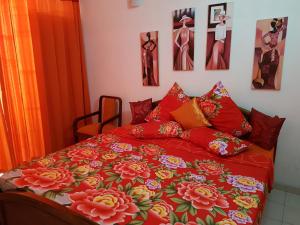 科伦坡塔姆比利岛斯图斯旅舍的一张带红色棉被和鲜花的床