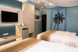 垦丁大街垦丁白沙滩旅店的酒店客房设有两张床和一台平面电视。
