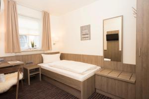 马尔克泰登费尔德Hotel Mainblick Garni的小房间设有床和镜子