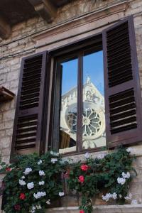 鲁沃迪普利亚Appartamento Antica Ruvo的倒映在建筑物中的带时钟的窗户