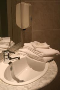米德尔克尔克B&B Geste d' Alice的浴室水槽和台面上的白色毛巾