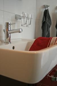 格赫伦-莱宾Villa Harmonie W2的墙上的红色毛巾和白色水槽