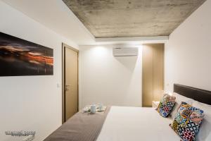 阿威罗Innapartments - São Gonçalinho的卧室配有一张白色床,墙上挂有绘画作品