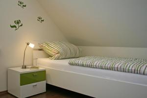 格赫伦-莱宾Villa Harmonie W2的一间卧室,配有一张带台灯的床头柜