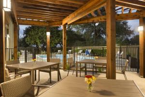 圣安东尼奥Country Inn & Suites by Radisson, San Antonio Medical Center, TX的一个带桌椅的庭院和一个游泳池