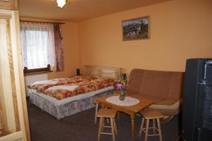 兹蒂尔普里瓦乌巴基民宿的一间卧室配有一张床、一张沙发和一张桌子