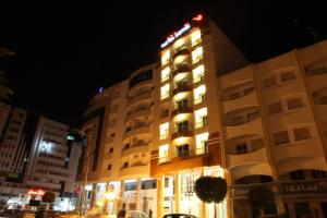 斯法克斯Pacha hotel的城市的一座建筑,晚上有灯光