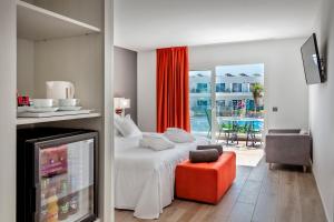 科拉雷侯科拉莱霍巴塞罗沙滩酒店的一间卧室配有一张床、一把椅子和电视