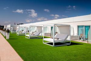 科拉雷侯科拉莱霍巴塞罗沙滩酒店的坐在草坪上的一排白色椅子