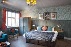 斯劳The Ostrich Inn Colnbrook London Heathrow的一间卧室设有一张床和蓝色的墙壁