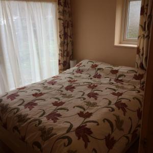 巴拉Ty'r Afon - River Cottage的卧室内的一张床铺,配有花卉床罩