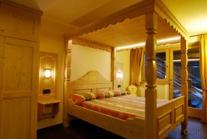 利维尼奥Residence Baita Cusini的一间卧室配有一张四柱床和天蓬