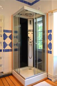Miniac-Morvan兰奈古博特酒店的浴室设有玻璃淋浴间,铺有蓝色和白色的瓷砖