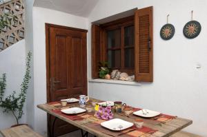 斯卡拉埃雷索Sappho House的一张木桌,上面放有盘子和食物