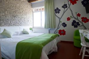 昆亚纳Izalde的卧室配有一张床,墙上挂着鲜花
