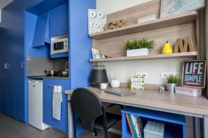 瓦伦西亚科莱焦梅尔公寓式酒店的一间拥有蓝色墙壁的办公室和一张带笔记本电脑的书桌