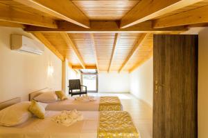 罗希姆诺Polyxenia Suites的一间卧室设有两张床和木制天花板