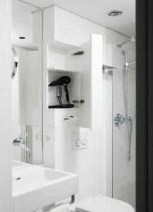 图恩施罗斯堡精品酒店 的白色的浴室设有水槽和淋浴。