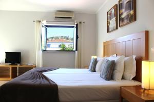 阿尔热祖尔Vicentina Hotel的卧室配有一张大白色床和窗户