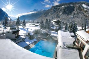 施图拜河谷新施蒂夫特查特奥斯加德霍夫里莱斯酒店的雪覆盖的房屋,设有游泳池