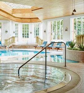 诺里奇Sprowston Manor Hotel, Golf & Country Club的一座带蓝色椅子的游泳池