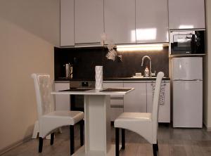 波普拉德Apartment Centrum number 8的厨房配有桌椅和冰箱。