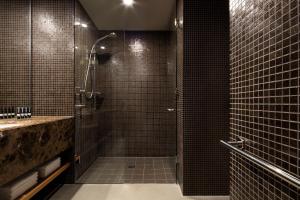 堪培拉王国酒店的浴室设有黑色瓷砖淋浴。