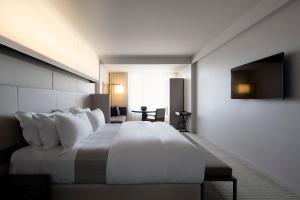 堪培拉王国酒店的酒店客房设有一张大床和一台电视。