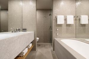 堪培拉王国酒店的带浴缸、盥洗盆和卫生间的浴室