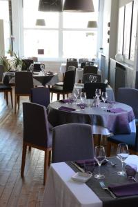 圣布里文莱丝皮恩Logis Le Petit Trianon的用餐室配有桌椅和酒杯