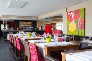 里姆斯特马博图斯酒店的餐厅的一排桌子和红色椅子