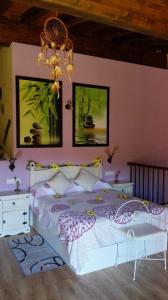 LancharejoCasa Rural Rosa Magica的卧室配有白色的床和吊灯。