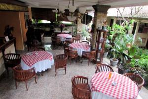 沙努尔格利亚阿玉酒店 的餐厅设有红色和白色的桌椅