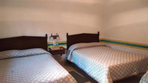 特基斯基亚潘Hotel Los Mezquites的一间客房内配有两张床的房间