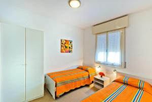 比比翁Apartments in Bibione 25584的一间卧室设有两张床和窗户。
