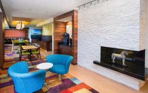 昆西昆西万豪费尔菲尔德客栈&套房酒店的客厅设有壁炉和蓝色椅子