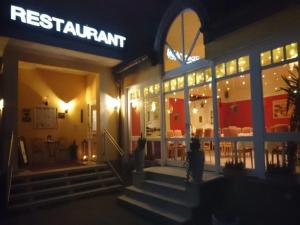 韦因斯特拉塞地区瓦亨海姆戈尔巴切尔酒店的一间晚上在餐厅前面有标牌的餐厅