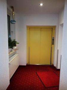 韦因斯特拉塞地区瓦亨海姆戈尔巴切尔酒店的红色地毯的房间里一扇黄色的门
