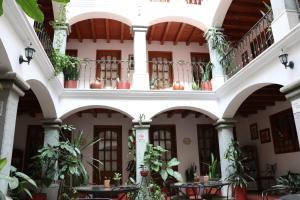 瓦哈卡市Hotel Casa de la Tía Tere的一座带桌子和盆栽植物的建筑的庭院