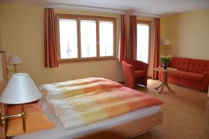 韦尔申罗尔克鲁兹加斯霍夫酒店的一间卧室配有一张床和一张红色的沙发