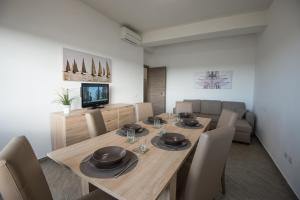 奇维塔韦基亚La Casa del Porto Apartment的一间带木桌和椅子的用餐室