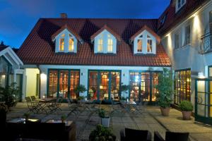卑尔根考夫曼斯霍夫罗曼蒂克酒店的大型房屋设有带桌椅的庭院