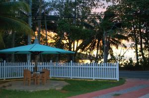 马埃岛贝拉扎尔区88天自助假日酒店 的白色围栏旁的一张带蓝伞的桌子