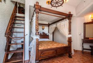 佩里萨波尔图佩里萨酒店的一间卧室设有木制天蓬床和楼梯。
