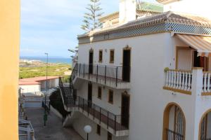 托雷维耶哈Molino Blanco的带阳台的白色建筑,背靠大海