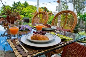 希洛Hale Kawehi B&B Guesthouse的一张桌子,上面放着两盘食物和橙汁
