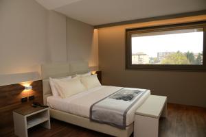 威尼托自由堡BW标志罗马酒店的一间卧室设有一张大床和一个窗户。